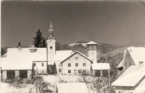 V sredini cerkev sv. Križa, levo od nje nekdanja občina, desno gasilski dom.
Foto Vojko Lovše. Poslana 26.1. 1963. title=