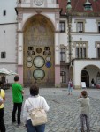 Mestna hiša z uro, ki kaže tudi koledar svetnikov, letne čase, dopolnjena pa je tudi s proletarskimi freskami novejšega časa title=